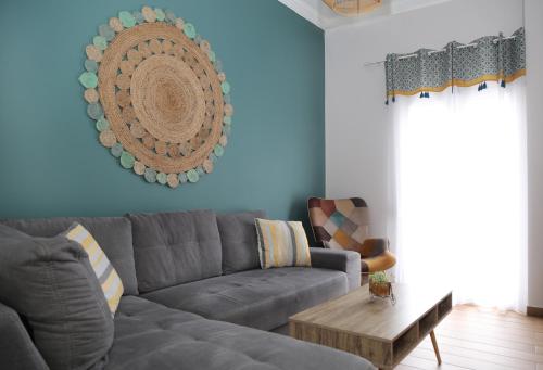 un soggiorno con divano grigio e tavolo di Sitia Cozy Apartment a Sitia