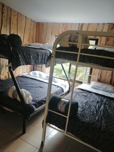 a room with three bunk beds and a window at Quinta privada con cabaña y piscina temperada in Cartago