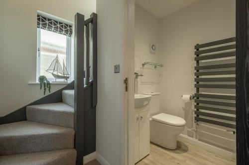 a bathroom with stairs and a toilet and a window at Sunset in Overstrand