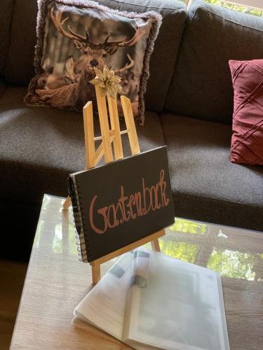 a sign on a coffee table in front of a couch at Chalet Sint-Hubertus Deluxe in Zutendaal