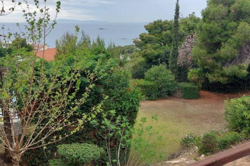a view of a garden with trees and the ocean at Sea Satin Anavyssos in Anavissos