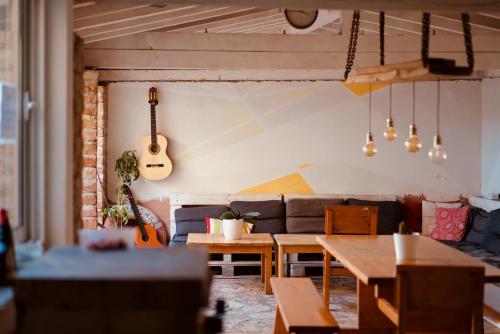 a living room with a couch and a guitar on the wall at Backpackers Home in Zadar