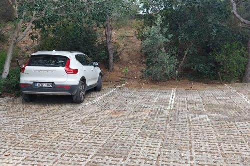 a white car parked in a parking lot at Sea Satin Anavyssos in Anavissos