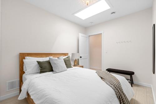 een slaapkamer met een groot wit bed en een dakraam bij The Olympia: Front Street Flats in Belleville