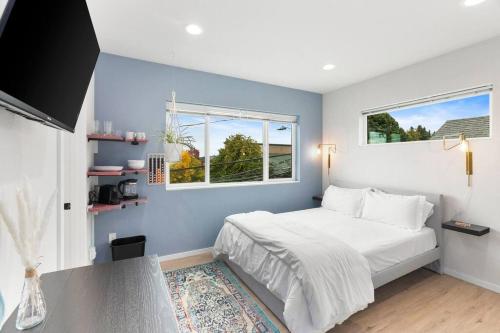 a bedroom with a white bed and two windows at Quinn's sweet suite - Micro Studio - 91Walkscore in Seattle