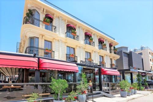 um grande edifício com guarda-sóis vermelhos numa rua em PREMIUM INN City Hotel & Restaurant Central Shopping Street Location ! em Famagusta