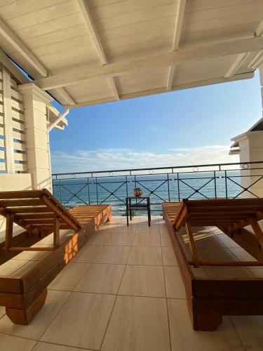 a balcony with benches and a view of the ocean at Rozos House in Loutsa