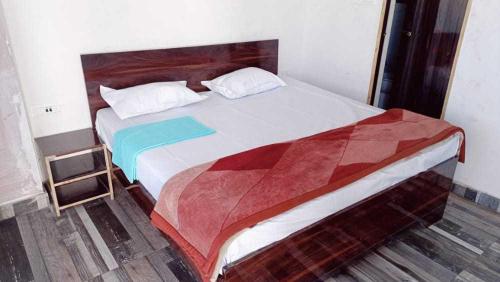 a bedroom with a large bed with a wooden headboard at OYO The Moonshine Hotel in Charkhi Dādri