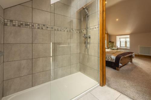 uma casa de banho com um chuveiro e uma porta de vidro em The Old English Barn em Bacton