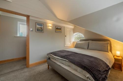 a bedroom with a large bed in a attic at Coach House Cottage in Weybourne