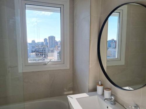 baño con espejo, lavabo y ventana en Sunny Belgrano Full Amenities en Buenos Aires