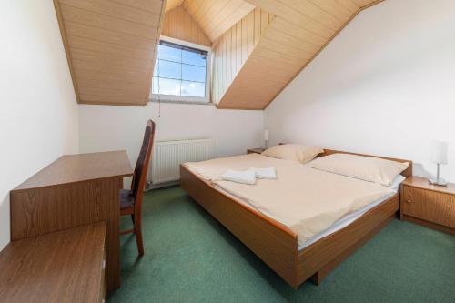 ein kleines Schlafzimmer mit einem Bett und einem Schreibtisch in der Unterkunft Penzion ob Ribniku in Podlehnik