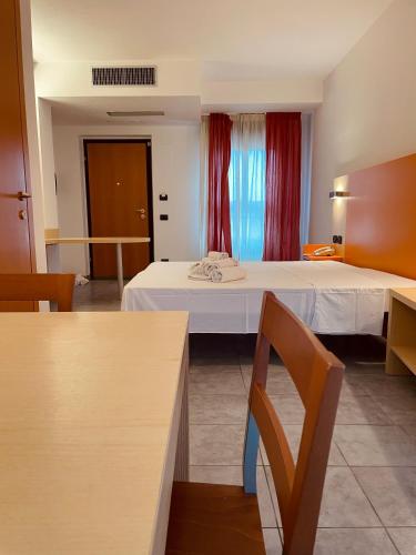 a hotel room with a bed and a table at Hotel Grecale - Venturina Terme in Venturina Terme