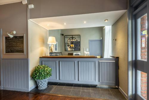 a bar in a hallway with a potted plant at White Horse Inn in Balmedie