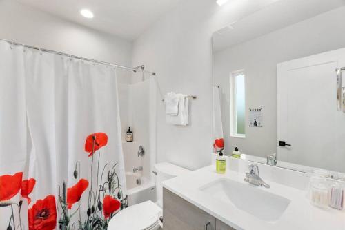 a white bathroom with red poppies on the shower curtain at Bodhi's sweet suite - Micro Studio - 91Walkscore in Seattle