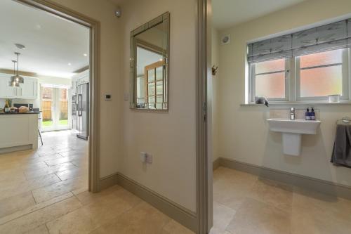La salle de bains est pourvue d'un miroir et d'un lavabo. dans l'établissement Long Meadow, à Great Bircham