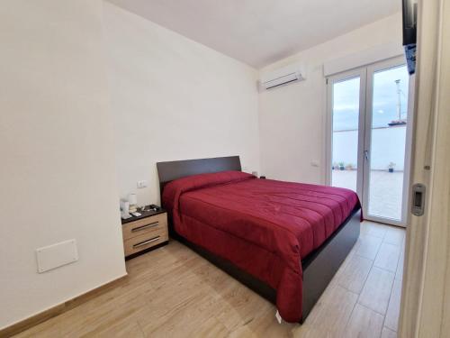 Sestu的住宿－Incanto，一间卧室设有红色的床和大窗户