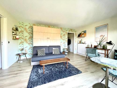 un salon avec un canapé et une table dans l'établissement Beau studio terrasse vue jardin - à 2 pas de la mer, à Deauville