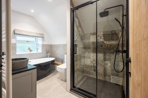 uma casa de banho com um chuveiro, um WC e um lavatório. em The Hideaway em Great Massingham