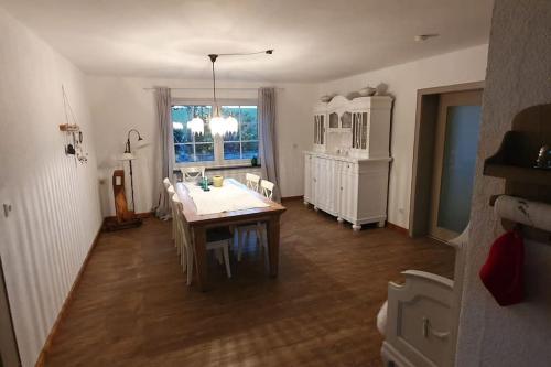 uma sala de jantar com uma mesa e cadeiras e uma janela em Ferienwohnung am Wald **** 