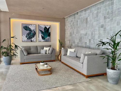 a living room with two couches and a table at Flat Unitá Homestay in Praia Grande