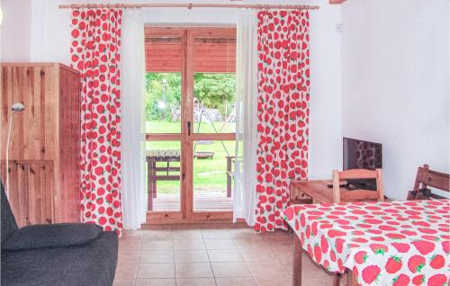 ChoczewoにあるBeautiful Home In Choczewo With 1 Bedrooms And Wifiの赤と白のカーテンとドアが付いたベッドルーム