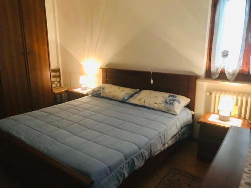 una camera da letto con un letto con lenzuola blu e una finestra di Casa vacanza da Berto a Stregna