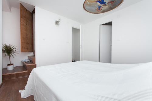Un dormitorio con una cama blanca y un espejo. en Apartment Zdenac, en Rovinj