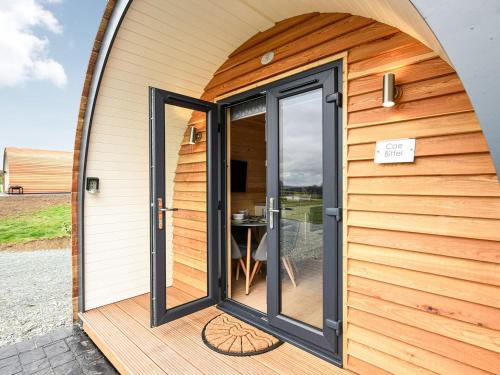 an open door of a tiny house with a patio at Cae Bitfel - Uk37082 in Llanwddyn