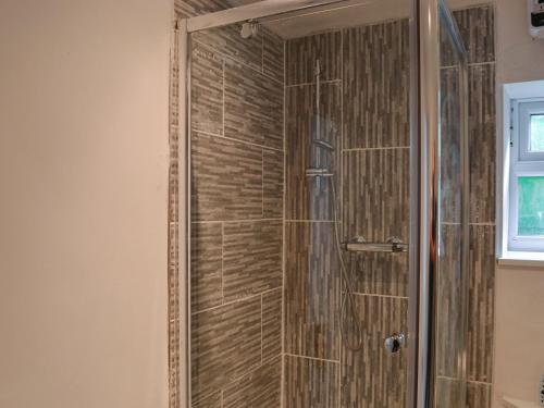 a shower with a glass door in a bathroom at Ellas Apartment in Skegness