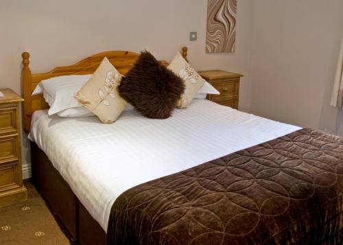 a bedroom with a bed with brown and white pillows at New Dungeon Ghyll Hotel in Great Langdale