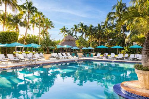 uma piscina no resort com cadeiras e guarda-sóis em The Palms Hotel & Spa em Miami Beach