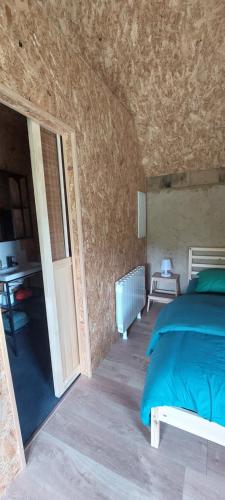a bedroom with a bed and an open door at De terre et de bois. in Éturqueraye