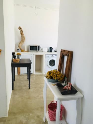 a kitchen with a table with a bowl of fruit on it at EOS - Appartement de charme et confort pour 4 personnes prés de la plage et du coeur de Koufonissi in Koufonisia