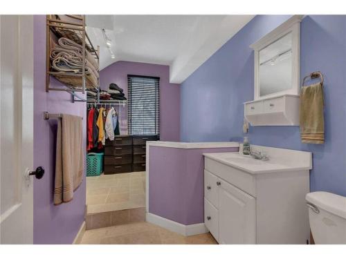 a purple bathroom with a sink and a toilet at Over 200' of Shoreline on Foot Lake!! Great Fishing Year Round! in Willmar