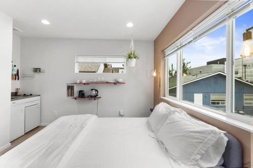 a bedroom with a white bed and a large window at Pingu's sweet suite - Micro Studio - 91Walkscore in Seattle