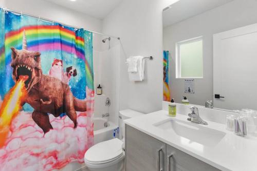 a bathroom with a monkey shower curtain with a rainbow at Pingu's sweet suite - Micro Studio - 91Walkscore in Seattle