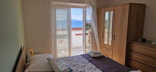 a bedroom with a bed and a sliding glass door at Rooms Bambina in Lun