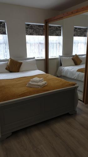 a bedroom with two beds and two windows at Lower Main Street Apartment in Letterkenny