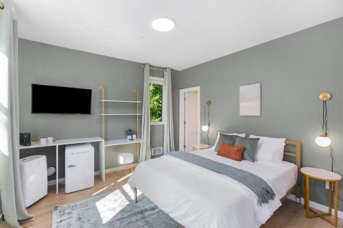 a bedroom with a large white bed and a tv at Ringo's Sweet Suite - 84 Walkscore in Seattle