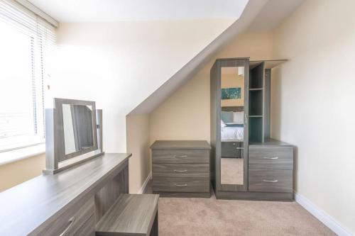a bedroom with a dresser and a mirror at Luxury 3 Bed house, 8 people, with street parking! in Bristol