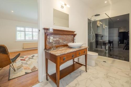 a bathroom with a sink and a shower at Low Wood in West Runton