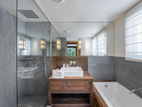 W łazience znajduje się umywalka, wanna i prysznic. w obiekcie Chalet de prestige avec jacuzzi, sauna et cinéma - FR-1-570-42 w mieście Saint-Martin-de-Belleville
