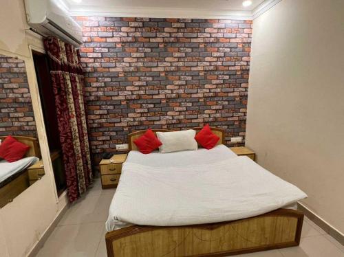 Cama en habitación con pared de ladrillo en OYO Flagship 80584 Hotel Anand, en Amritsar