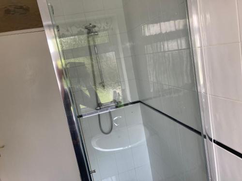 a bathroom with a glass shower with a sink at bungalow on the south coast & new forest in Lymington