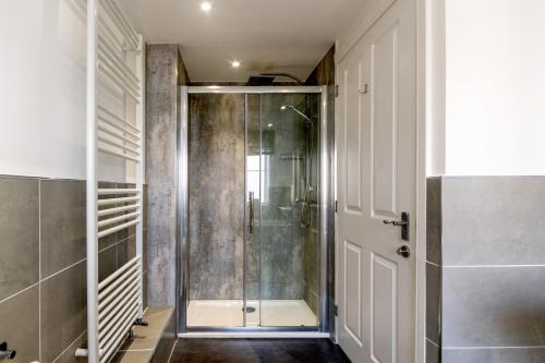 a bathroom with a shower with a glass door at Burbage View in Buxton