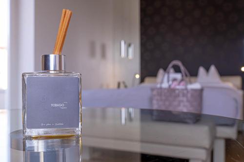 a bottle of perfume sitting on a table with a purse at Tobago in Garda