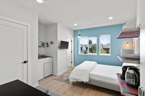 a bedroom with a white bed and a blue wall at Isla's sweet suite - Micro Studio - 91Walkscore in Seattle