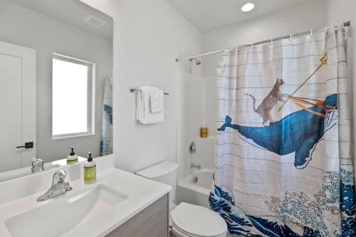 a bathroom with a shower curtain with a cat on an umbrella at Isla's sweet suite - Micro Studio - 91Walkscore in Seattle