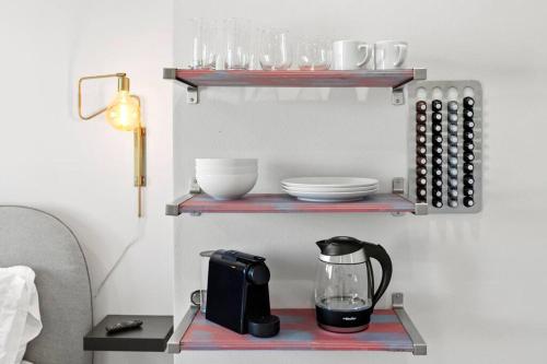 a shelf with a coffee maker and glasses on it at Isla's sweet suite - Micro Studio - 91Walkscore in Seattle